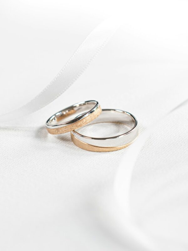 two wedding rings sitting on top of a white cloth